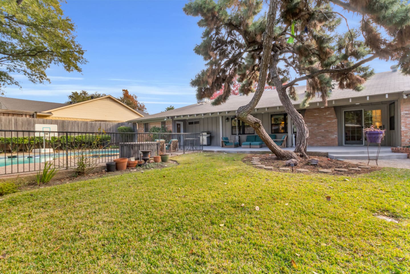 Spacious backyard with a manicured grassy area, providing plenty of room for kids to play, run, and enjoy outdoor fun.