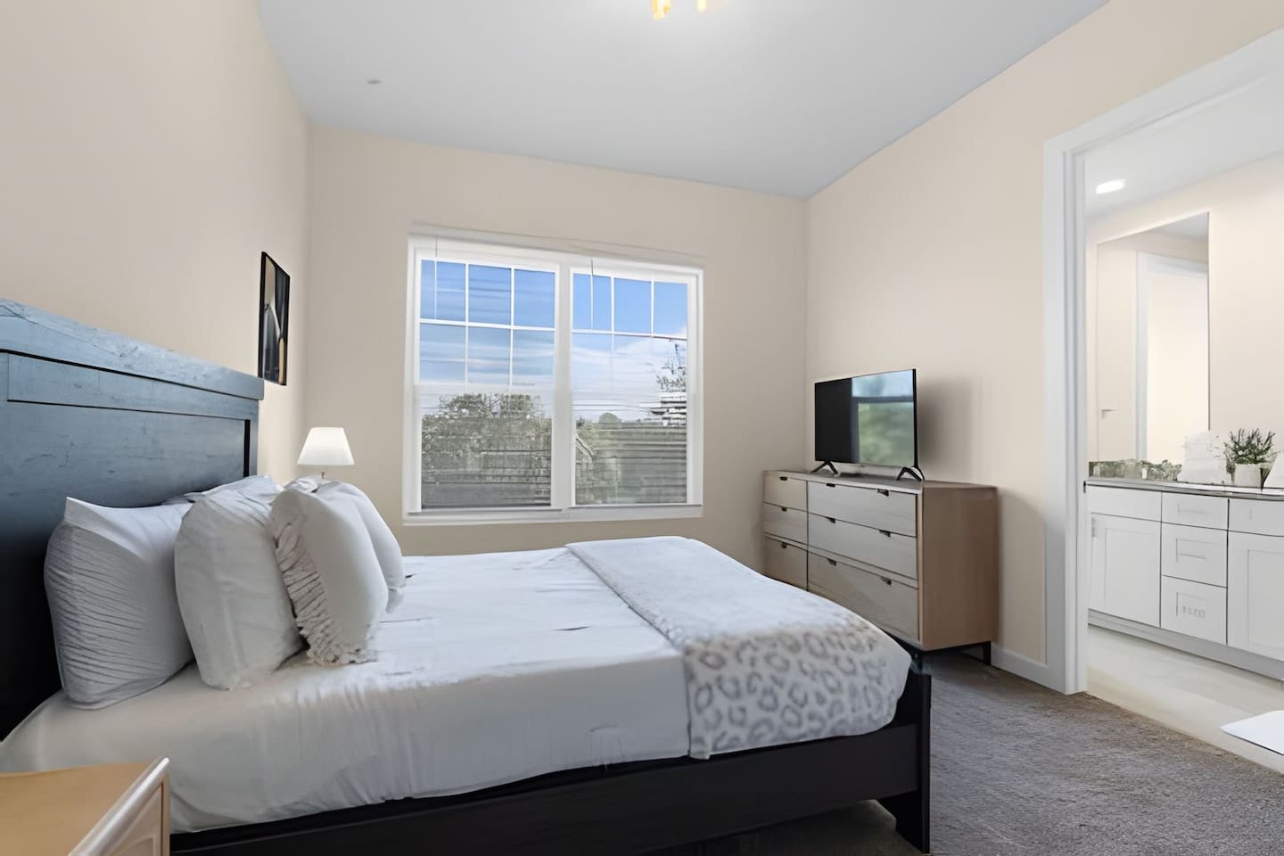 Well-lit bedroom with large windows offering beautiful views!