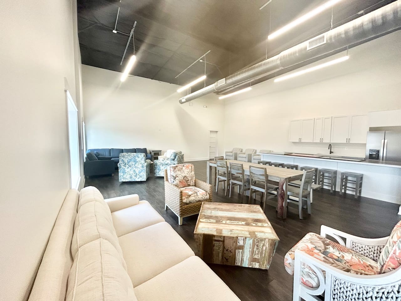 An expansive view of the community space, showing the mix of lounge seating and dining tables available for guest use.
