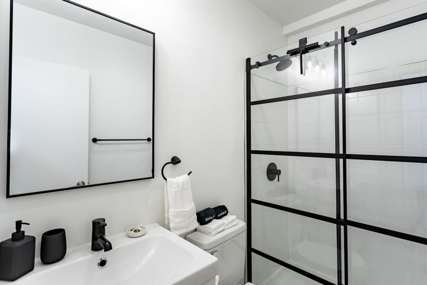 Stylish white and black interior full bathroom, combining modern design with functionality.