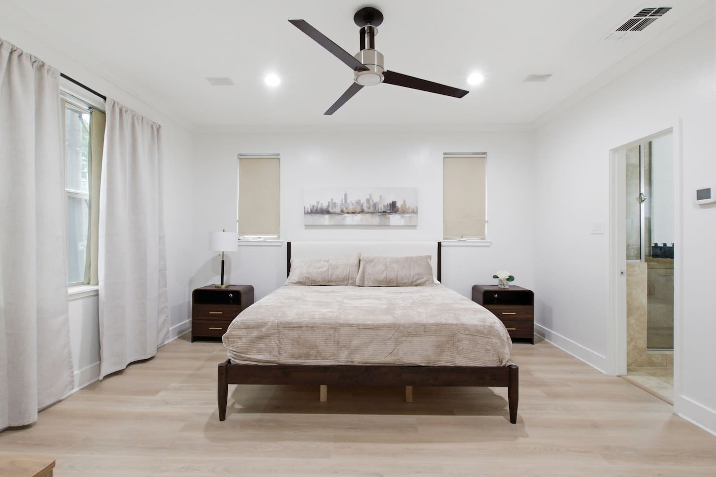Primary suite on the third floor with King bed, ceiling fan, Smart TV, and hardwood floors. Bright and calm with plenty of natural light and direct access to the en-suite bathroom.
