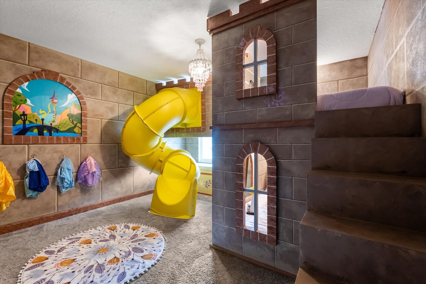 No princess bedroom is complete without a spiral slide, am I right? Let the littles enjoy some princess time in the Tangled themed castle bedroom with dress up clothes, spiral slide, a bench with beautiful lake views and a princess soundtrack.