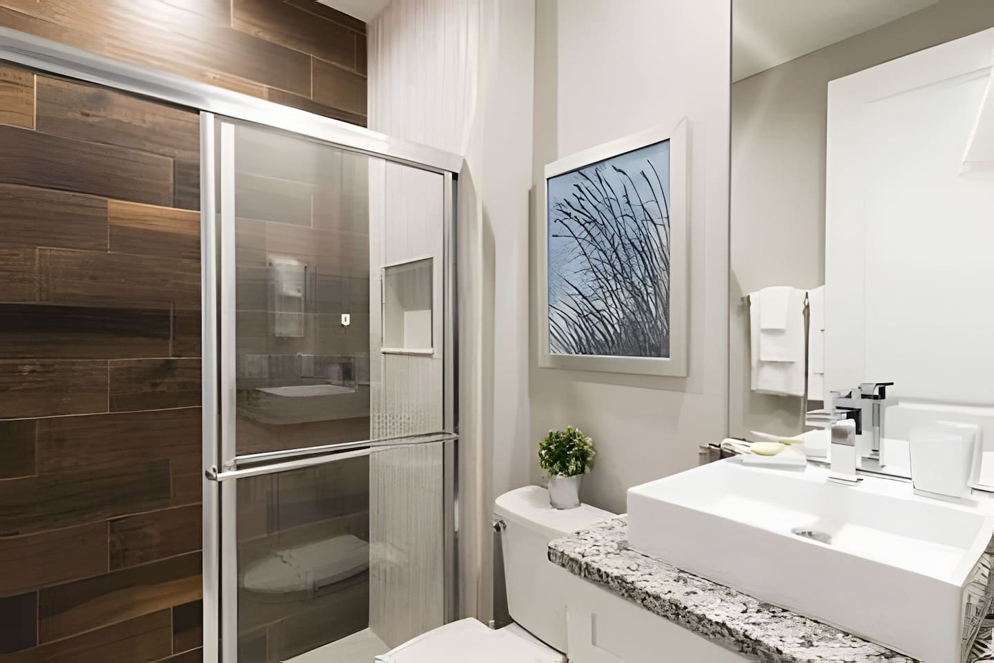 Private bathroom with sleek finishes, large shower, fresh towels, and thoughtful amenities.