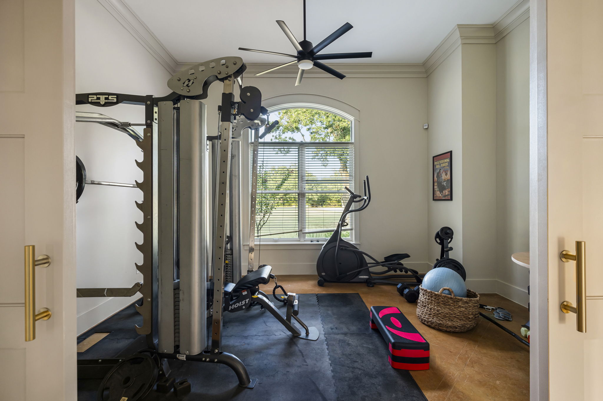 Stay active without leaving the house in a bright fitness room featuring a multi-station weight machine, elliptical, bench, and a variety of free weights. Additional equipment includes a stability ball, step platform, and resistance accessories.