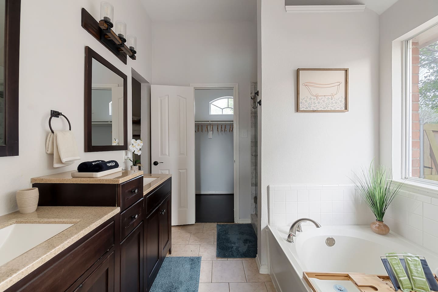 Step into this luxurious bathroom featuring a sleek sink and mirror combo, a inviting bathtub, and a spacious walk-in shower. Pamper yourself in style and comfort.