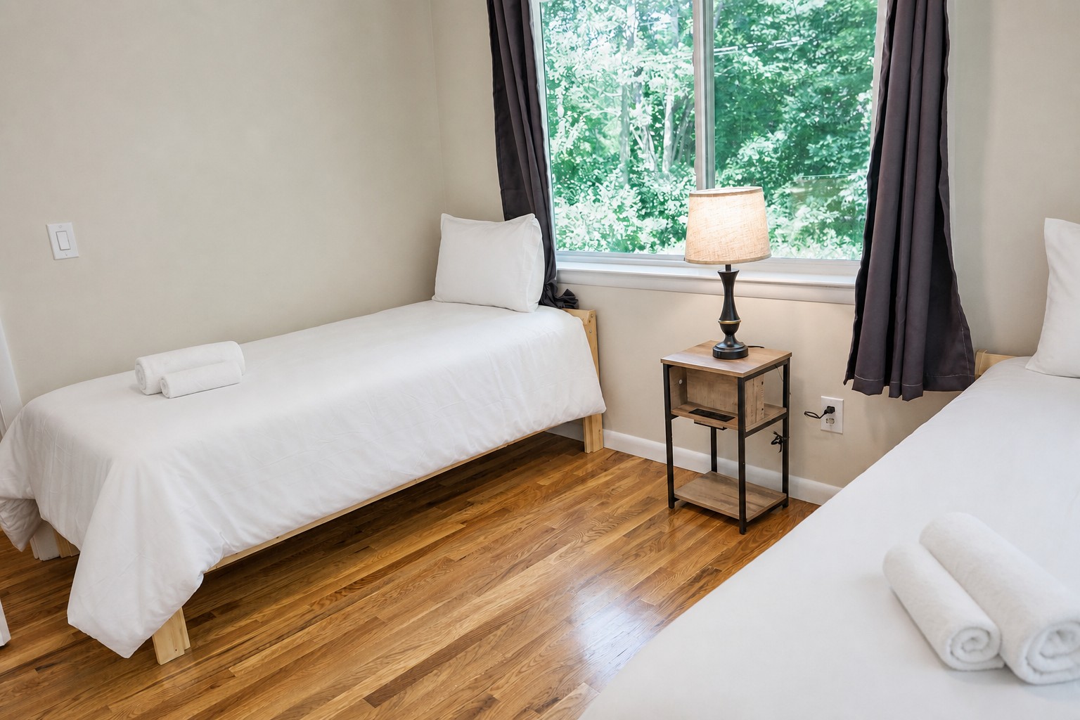 Twin bed by the window with a bedside lamp