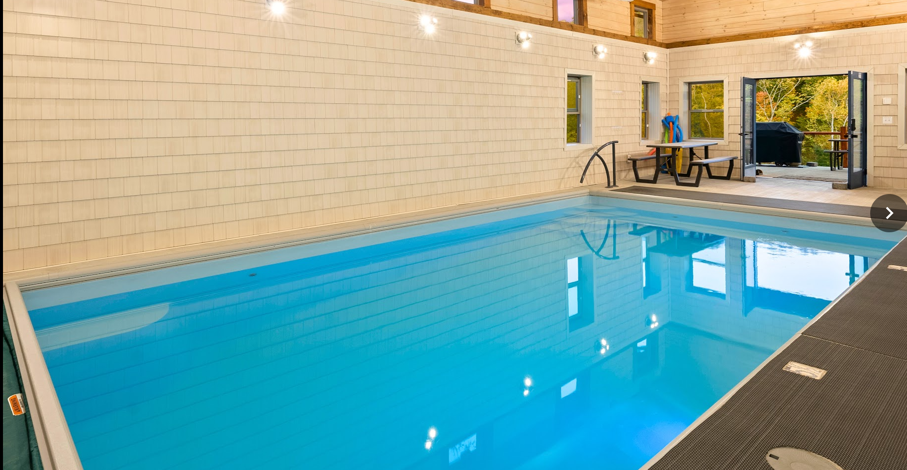 Luxury lodge in Hocking Hills featuring a private heated indoor pool with forest views