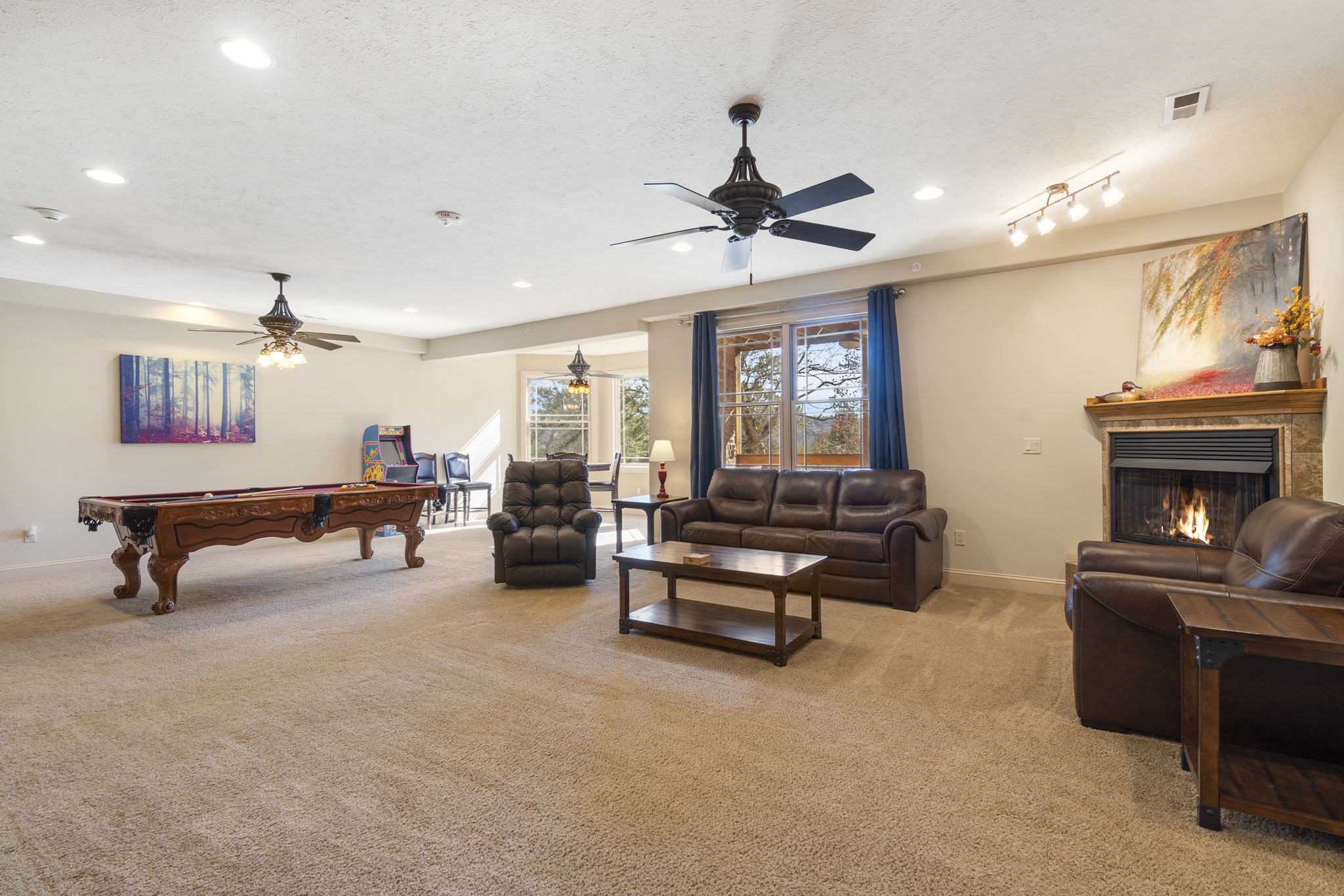 Lower level living and gaming space with electric fireplace, pool table, arcade games and more