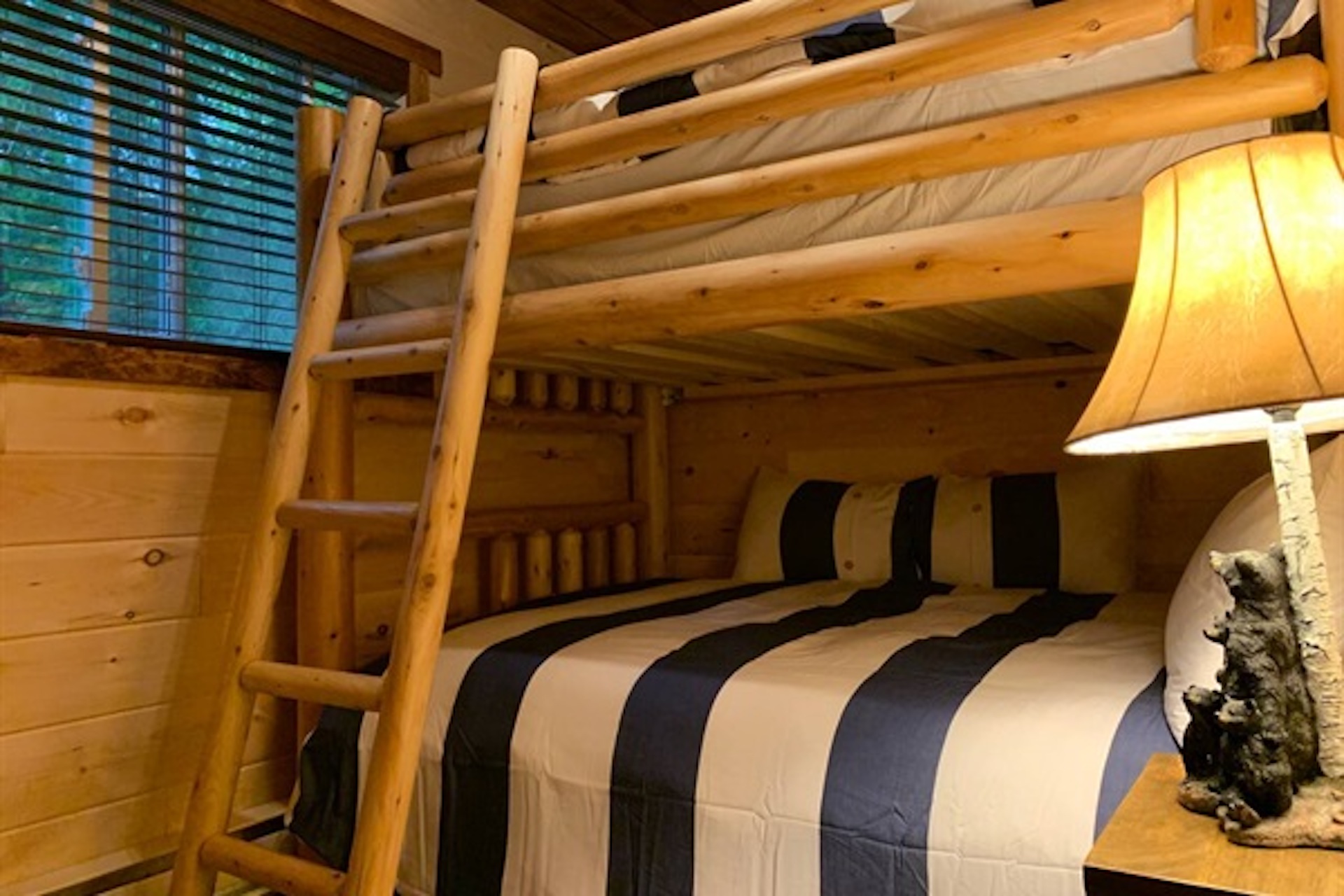 Bunk room with warm lighting and rustic wood finishes