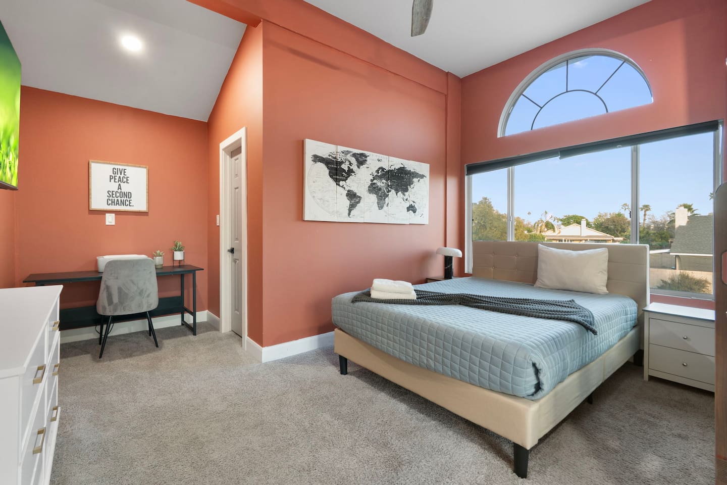 Bright, stylish bedroom with a dedicated workspace and expansive views.