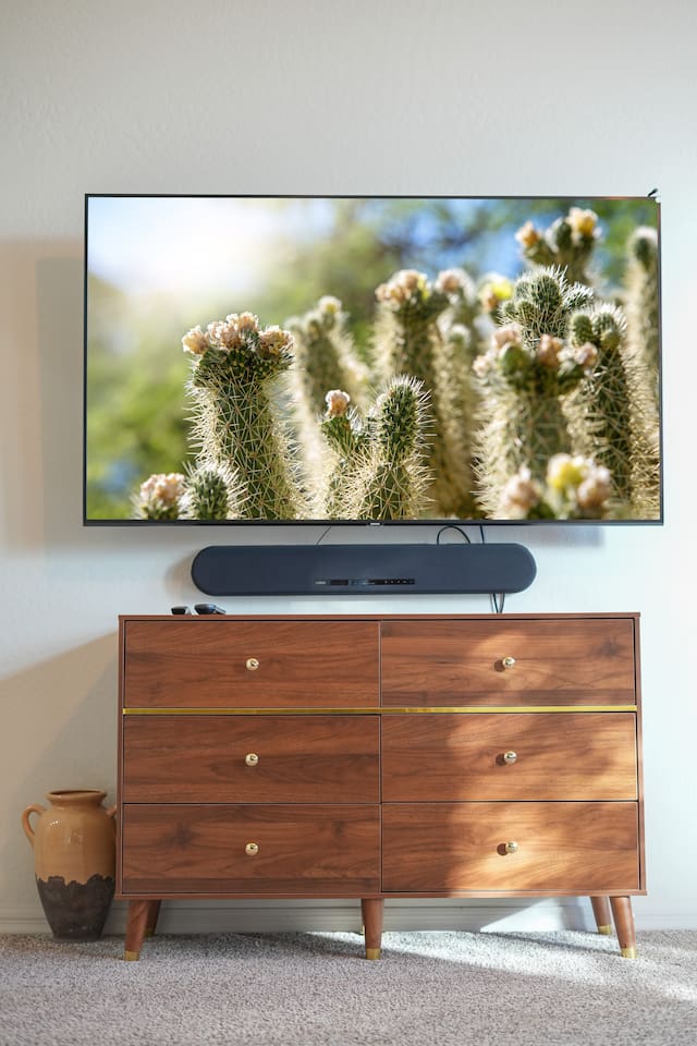 Smart TV mounted above a stylish dresser for relaxing evenings.