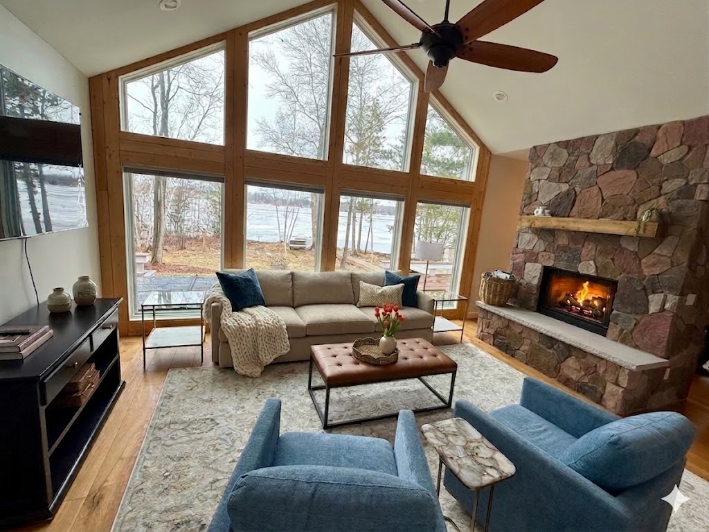 Unwind in the living room, featuring floor-to-ceiling windows with panoramic lake views. Whether you’re curling up by the roaring stone fireplace on a crisp evening or watching the sunrise with your morning coffee, this space is perfect for relaxation.