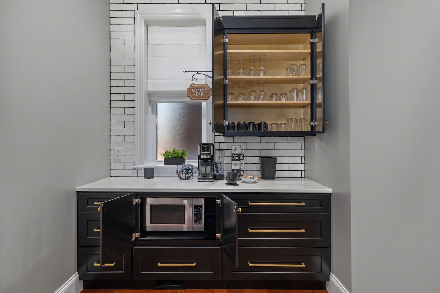 Visit the coffee bar to prepare either single servings or pots of coffee using grounds or pods. 
There's a variety of coffee mug sizes, drinking glasses or cups, and wine glasses to choose from.  
The microwave is tucked away in lower cabinet.