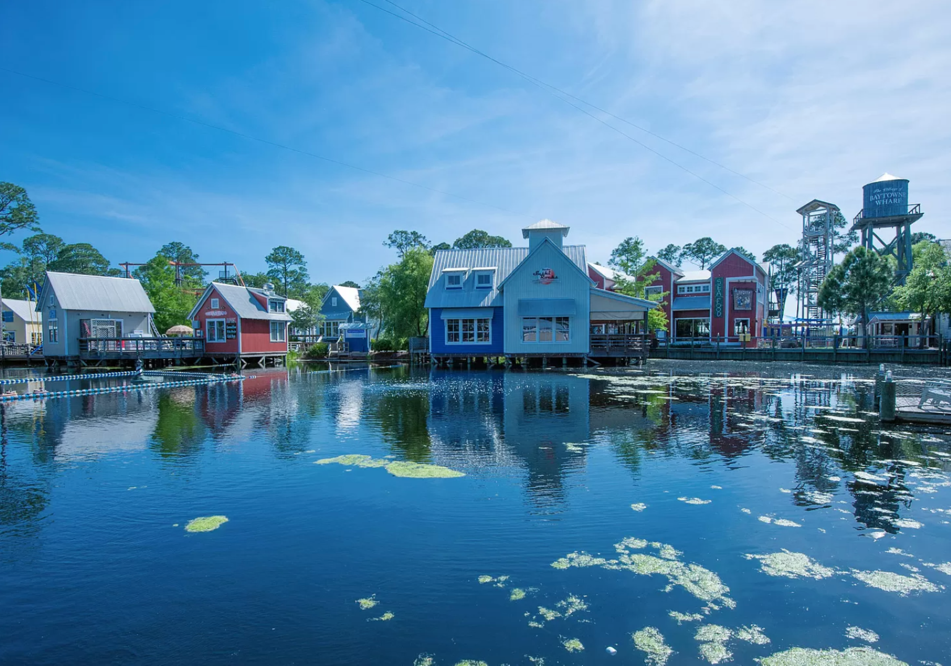 Colorful seaside village. Eccentric pastel-colored buildings rise alongside a tranquil canal, reflecting in the calm waters and creating a charming coastal atmosphere.