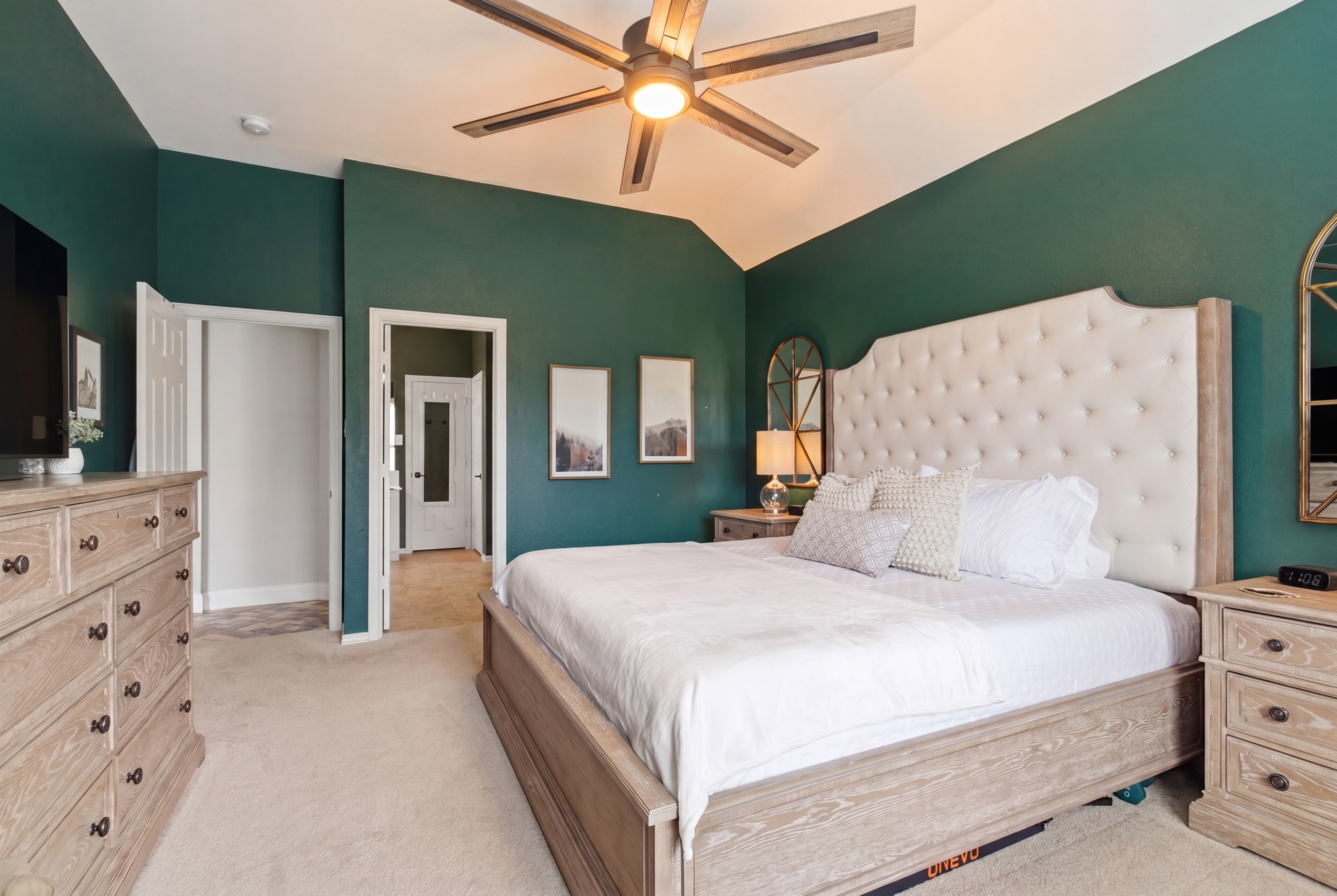 Spacious Master Bedroom with a King Bed, oversized dresser, and bright natural light from corner windows. Single-story layout keeps everything on one easy level.
