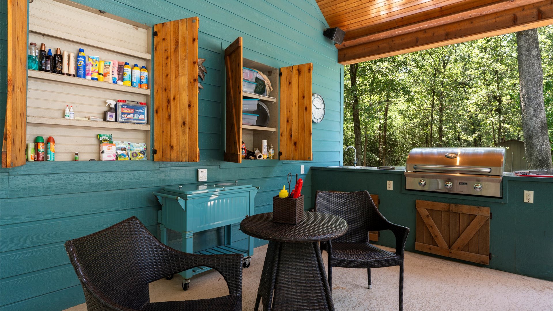 A well-stocked outdoor kitchen designed for convenience and relaxation! Equipped with a grill, seating area, and essentials like sunscreen and pool toys, this space is perfect for cooking, dining, and enjoying the outdoors in comfort