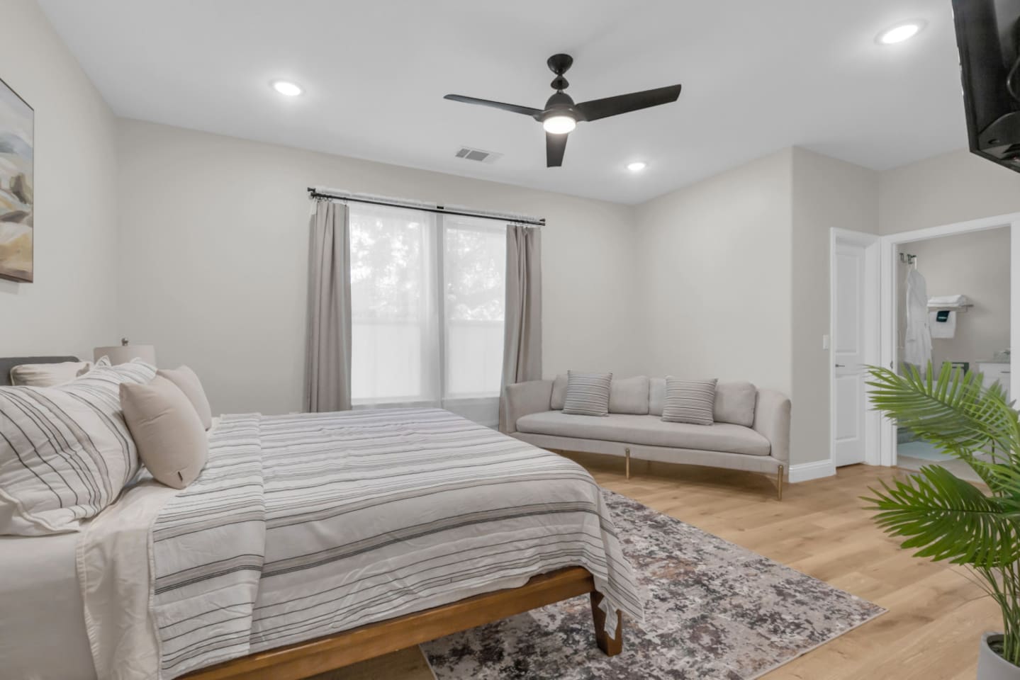 Master suite with mounted flat-screen TV and cozy seating.