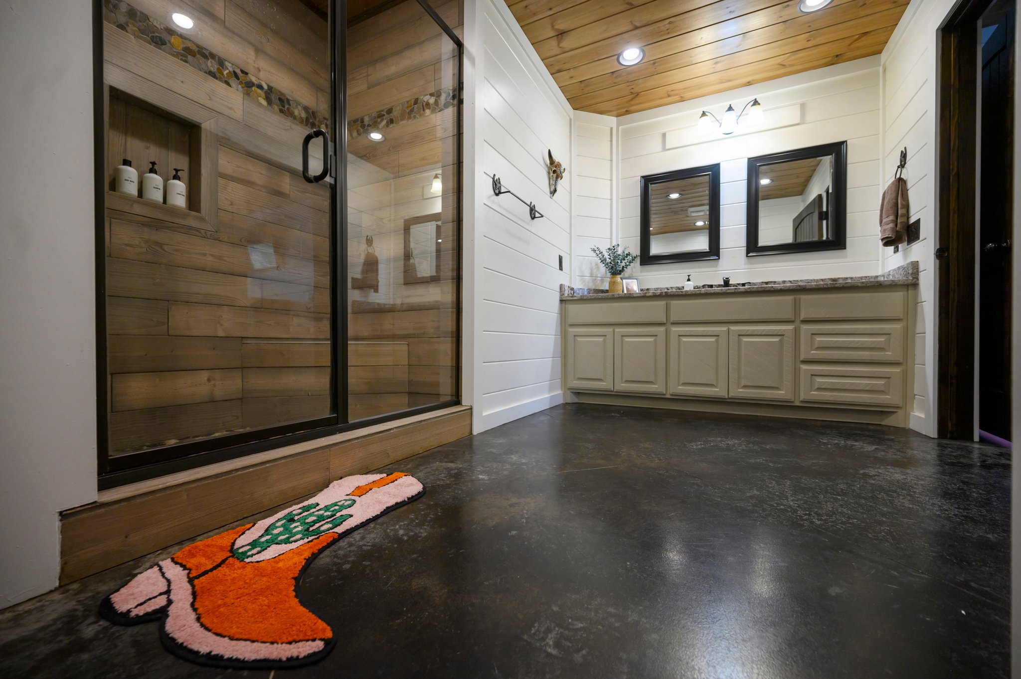 Enjoy the space and comfort of the en suite bathroom, with a walk-in shower, double sinks, and cowboy-inspired designs