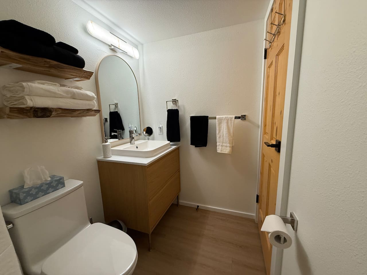 Main Floor Bathroom: Newly installed vanity offers ample counter space and storage, complemented by live edge shelving for that mountain feel.