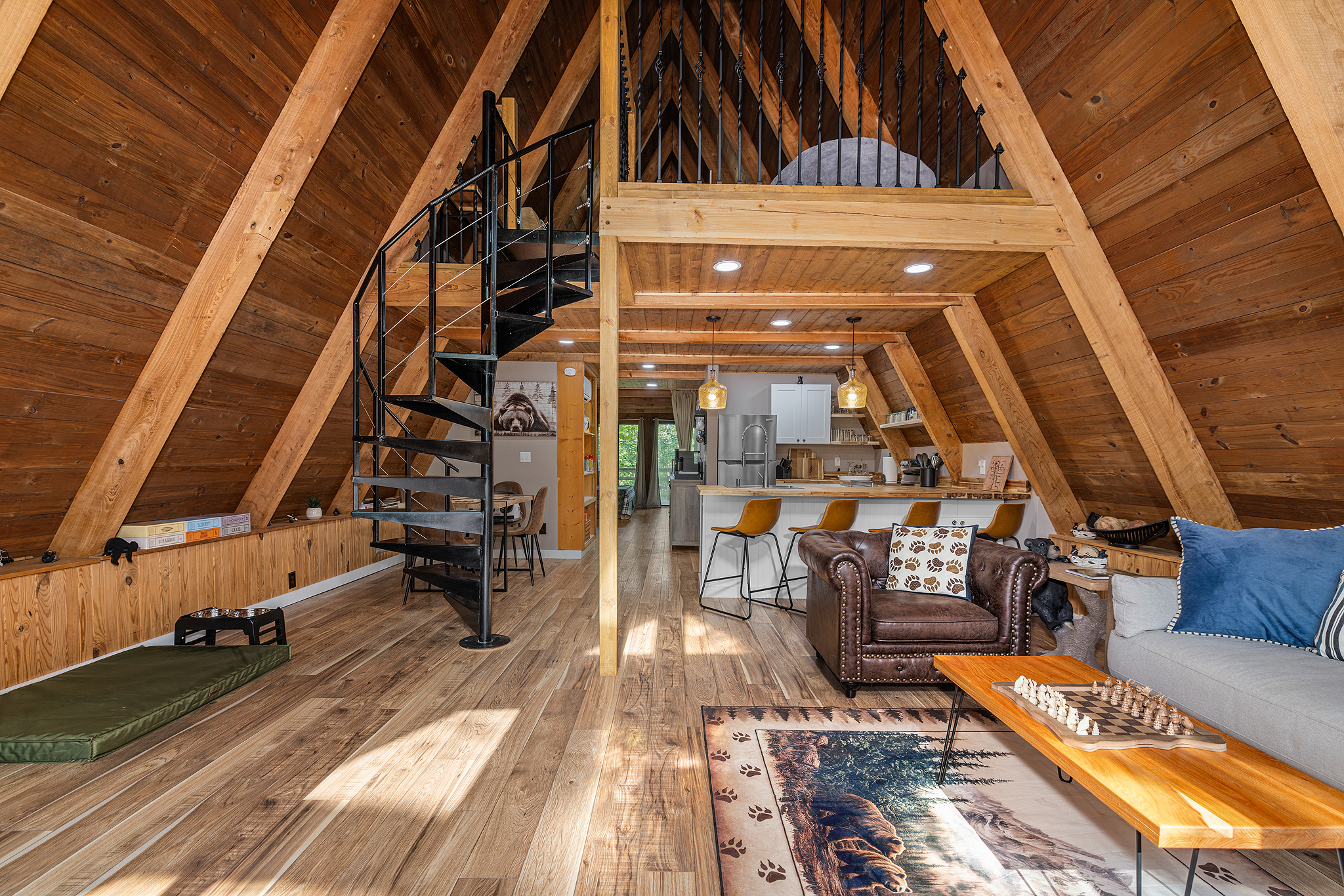 Open living with spiral staircase + loft.