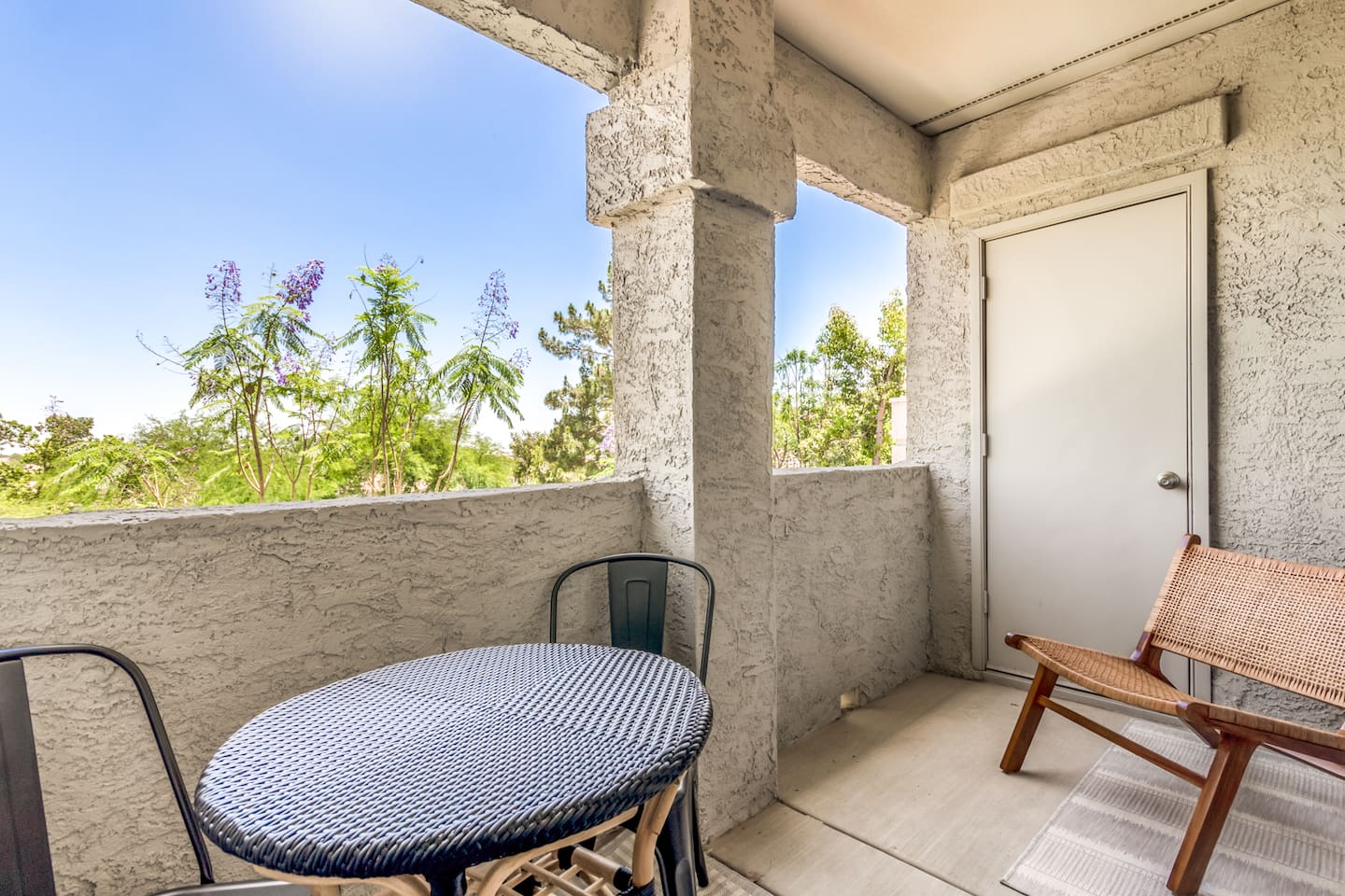 Outdoor balcony with chairs and a bistro table for a simple place to relax outside.