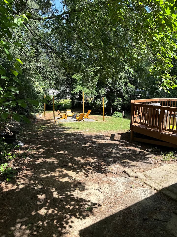 Spacious backyard with a gravel walkway provides open play areas and relaxing green space. 