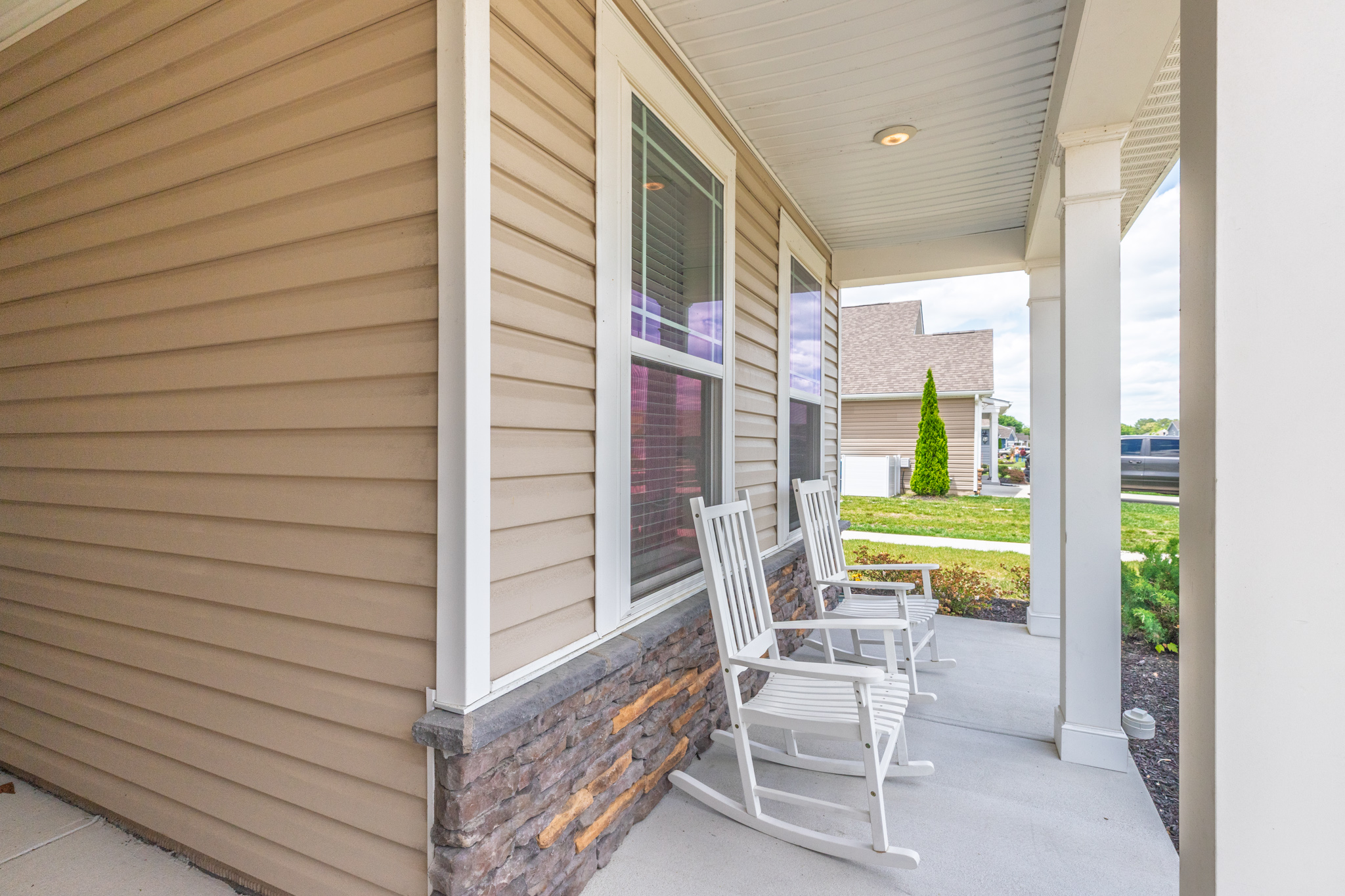 Relax on two rocking chairs beneath a covered porch—your perfect spot for morning coffee or evening chats.