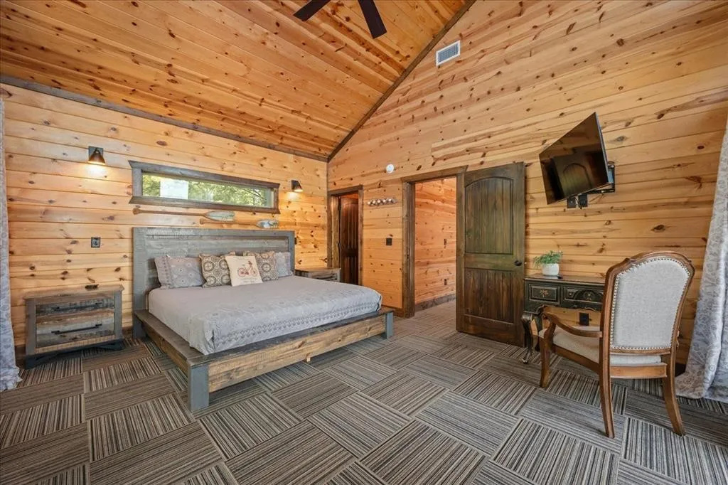 Upstairs bedroom with balcony access, shared bathroom to bunk room and TV.