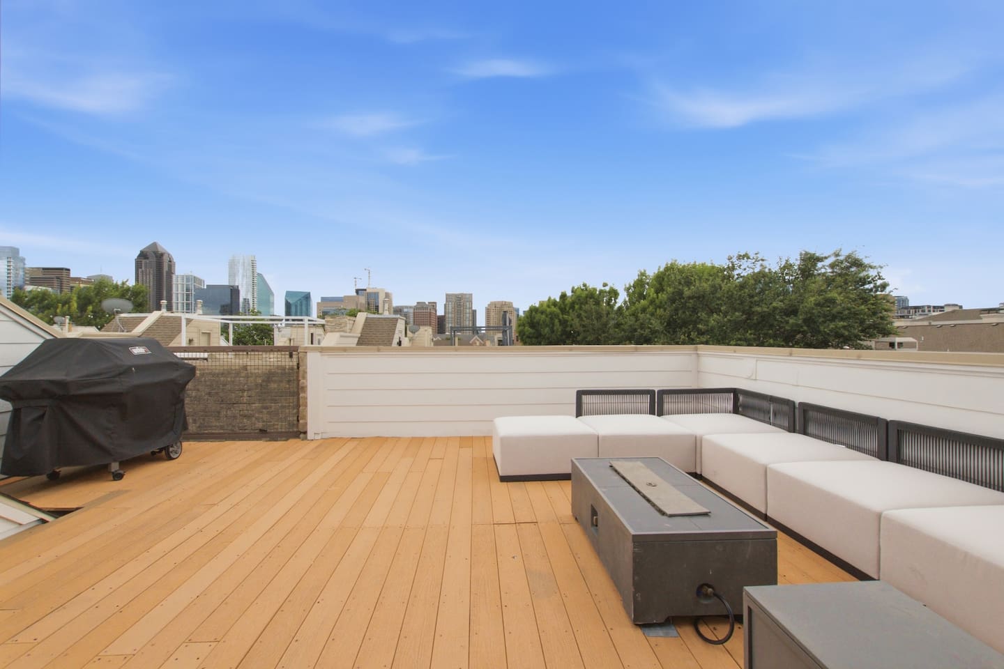 Propane BBQ grill and fire pit on the rooftop deck, ready for cookouts with a Dallas skyline view. Everything you need to grill out without leaving the comfort of your own rooftop.