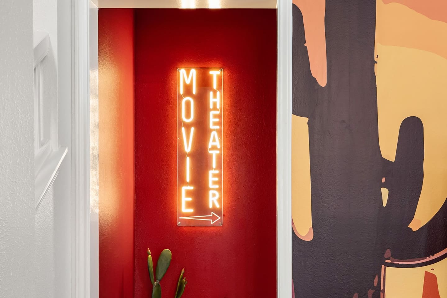 Lights, camera, relaxation! ✨  
This glowing neon sign marks the entrance to your very own private movie theater—just follow the arrow and let the show begin!