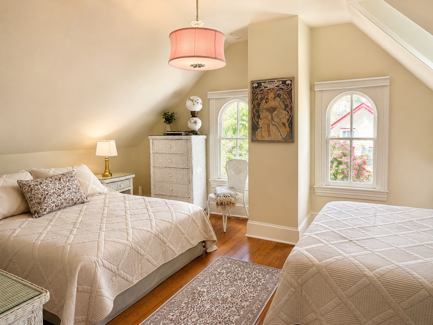 Another angle of the same room — golden light, original hardwood floors, and enough space for everyone to be comfortable up under the eaves.