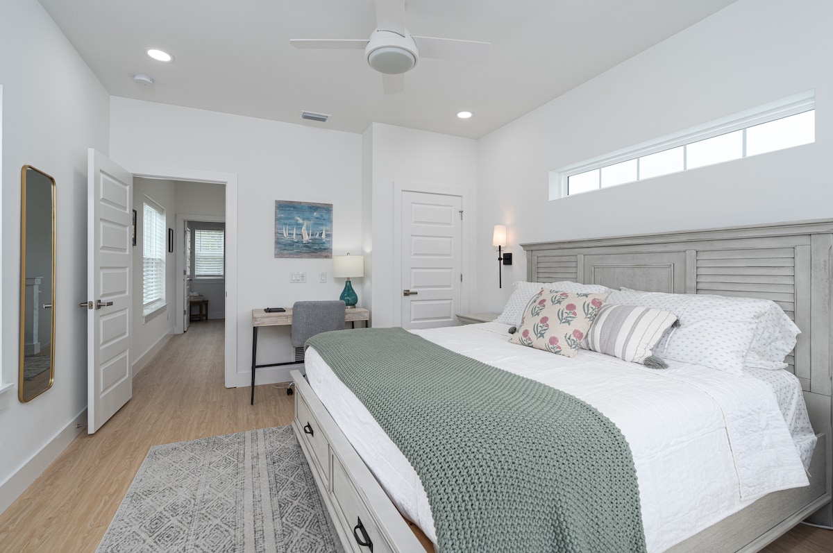 Clean light, a high transom window, and a king bed you will not want to leave. The en-suite is just through the door, which matters when two families share a house and nobody wants to queue for a shower.
