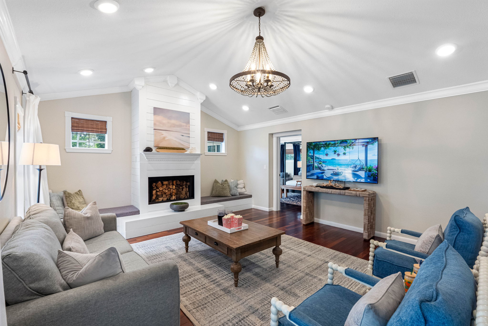 Modern touches, including recessed lighting and a mounted TV, complement the traditional charm of the wood-burning fireplace.