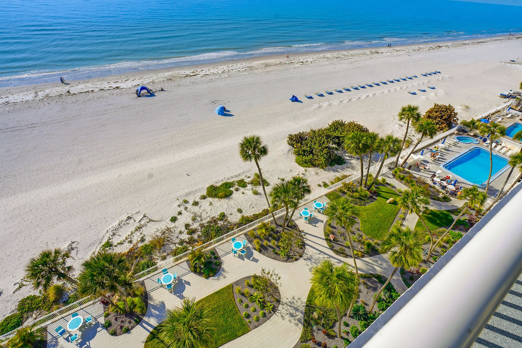 Stunning beachfront vacation rental with panoramic Gulf views, resort pool, and beautifully landscaped outdoor gathering spaces.