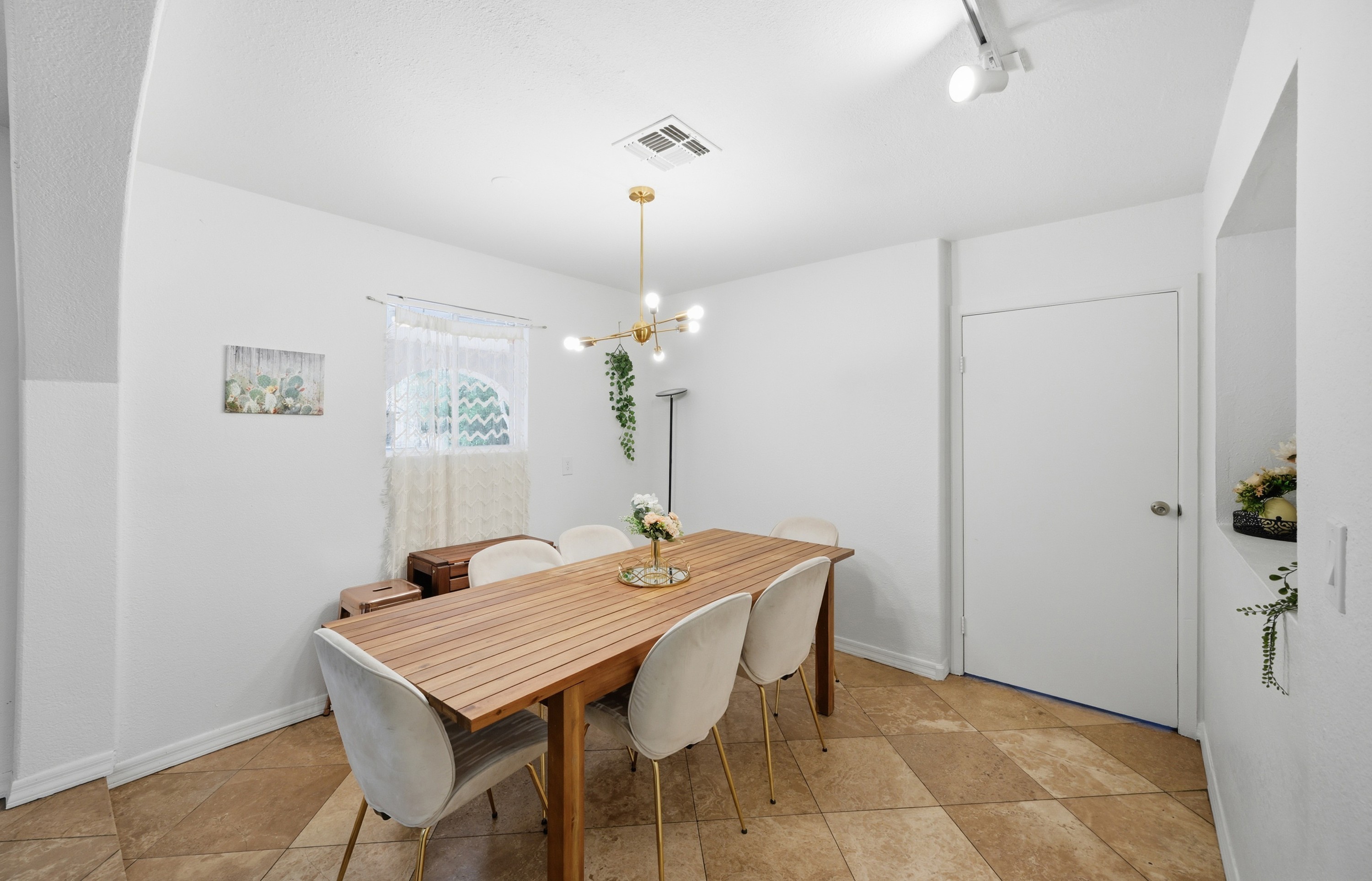 Gather for meals or game nights in this stylish dining room, featuring warm textured walls, modern lighting, and a cozy, intimate atmosphere.