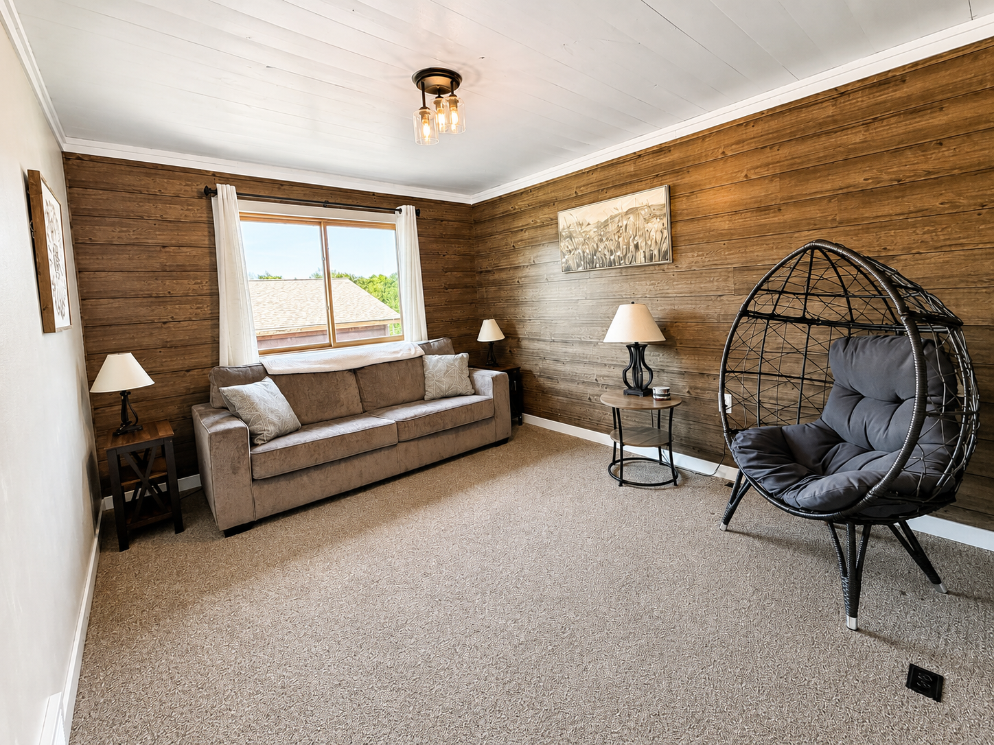 At the top of the steps separate sitting room with comfortable seating and a hanging chair gives guests another relaxing space to spread out.