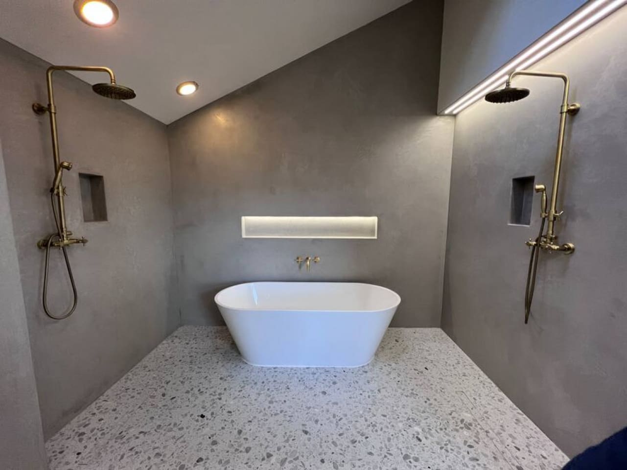 The primary suite has a new 120 sq ft private bathroom that is done in Moroccan plaster (walls) and Italian terrazzo (floors). It includes this 71" soaking tub and two showerheads, and a double faucet vanity.
