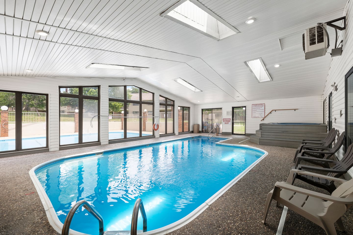 Indoor Pool Oasis: Splash into relaxation in this sunlit pool area with hot tub access!