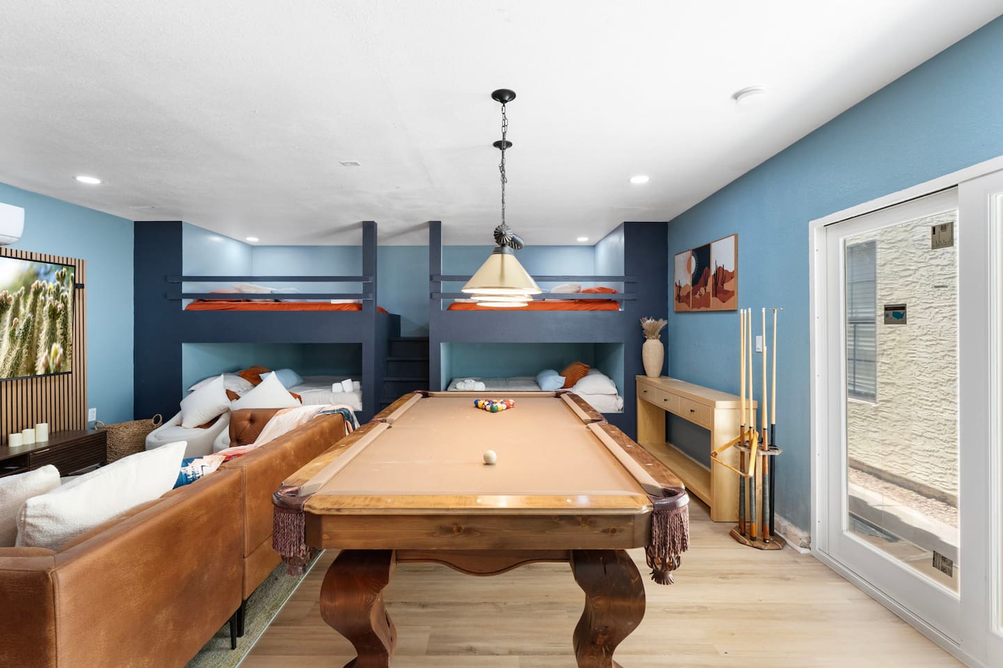 Game room with pool table, built-in bunks, and bold blue walls—the perfect space for guests to gather and play.