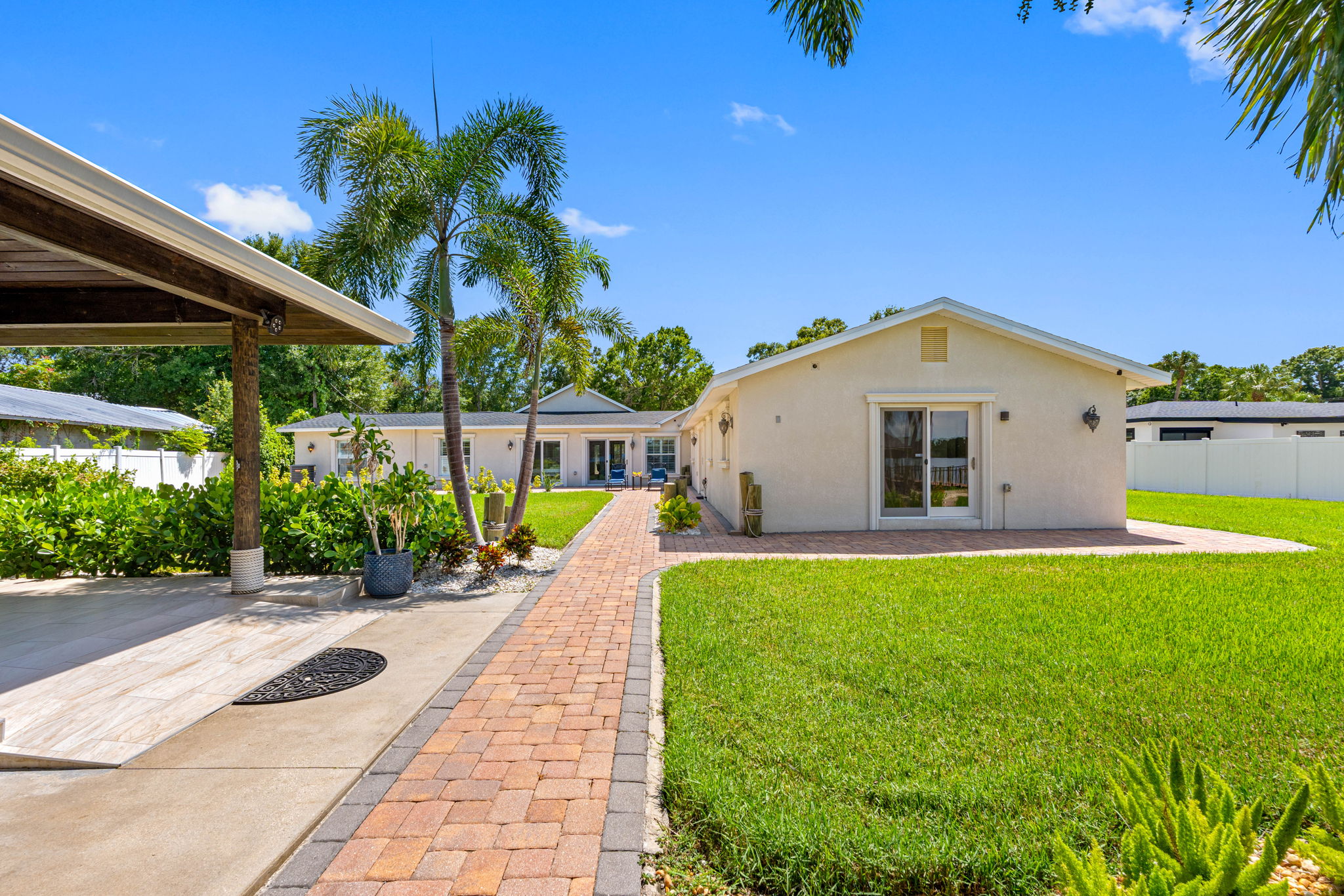 The combination of pavers, stone accents, and hardy tropical plants ensures a stylish yet easy-to-care-for outdoor space.