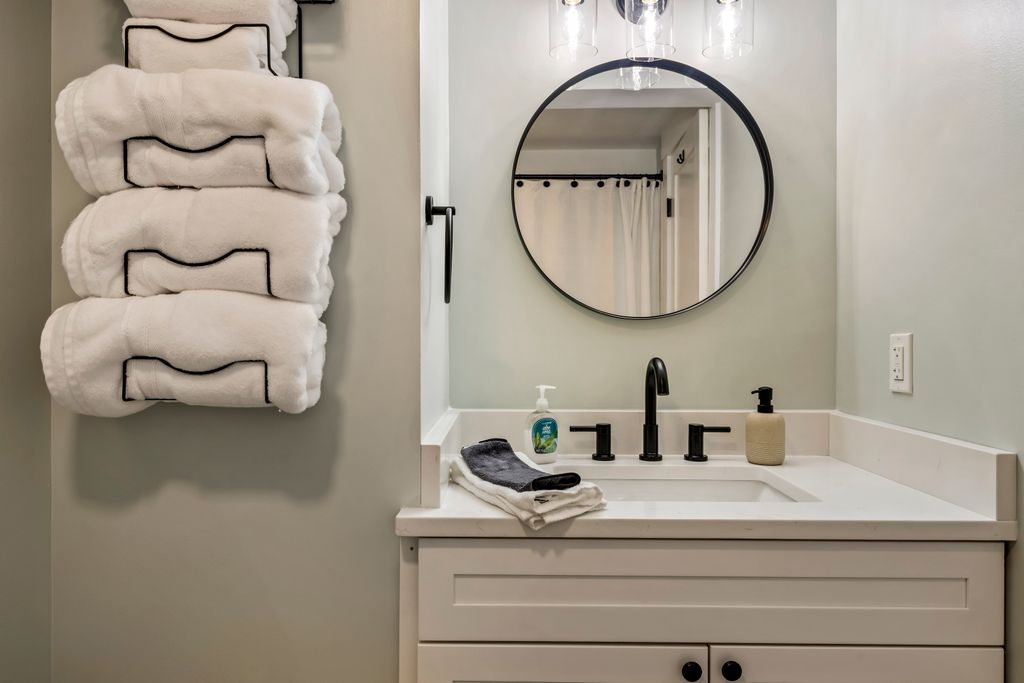 Full bathroom along the hallway with large shower, vanity, and storage.