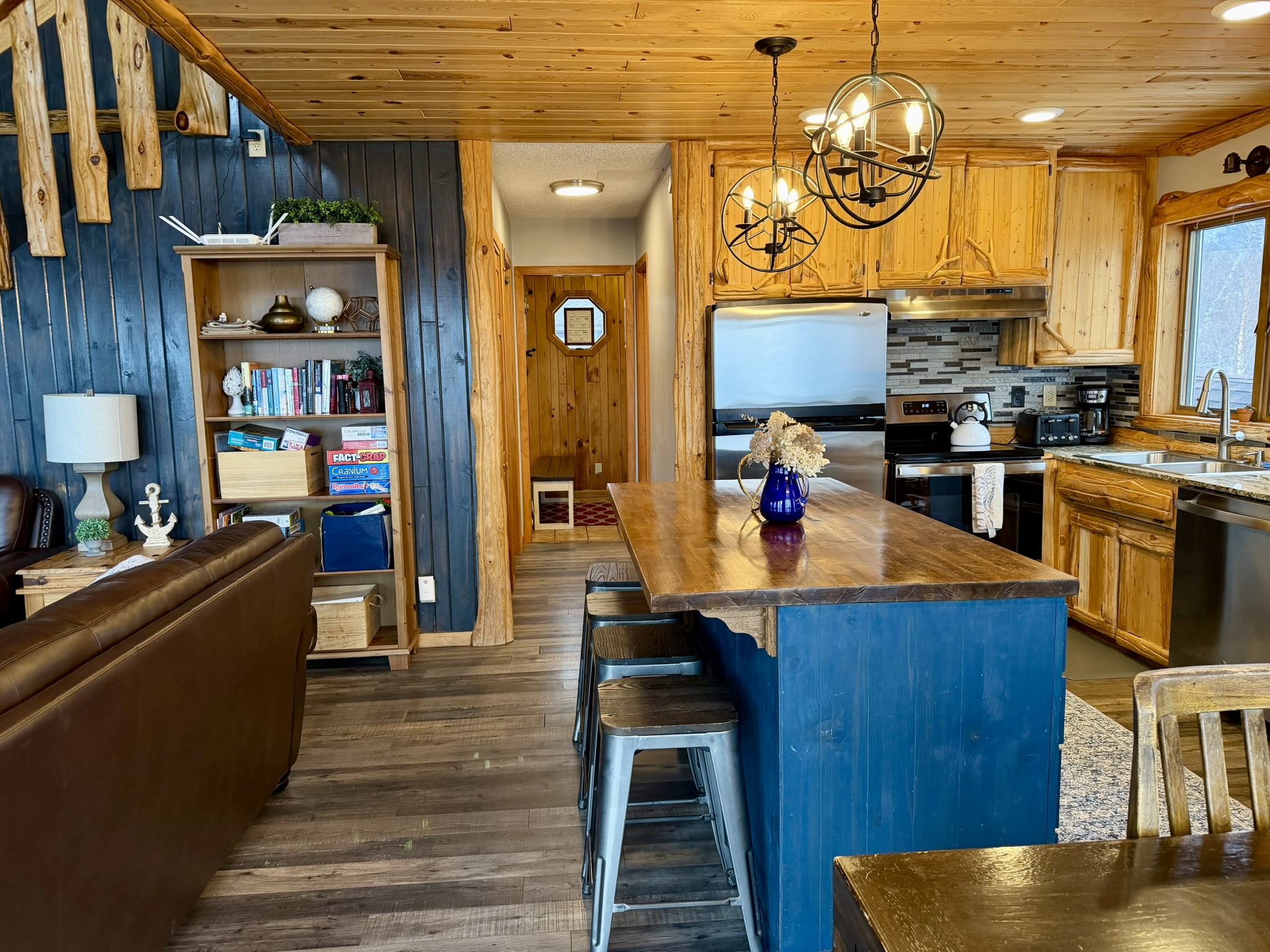 Step back in from the deck to a cozy hangout, with board games on the  shelf ready to play, the kitchen right there, and a warm, fun space to relax and reconnect after a day exploring the North Shore.