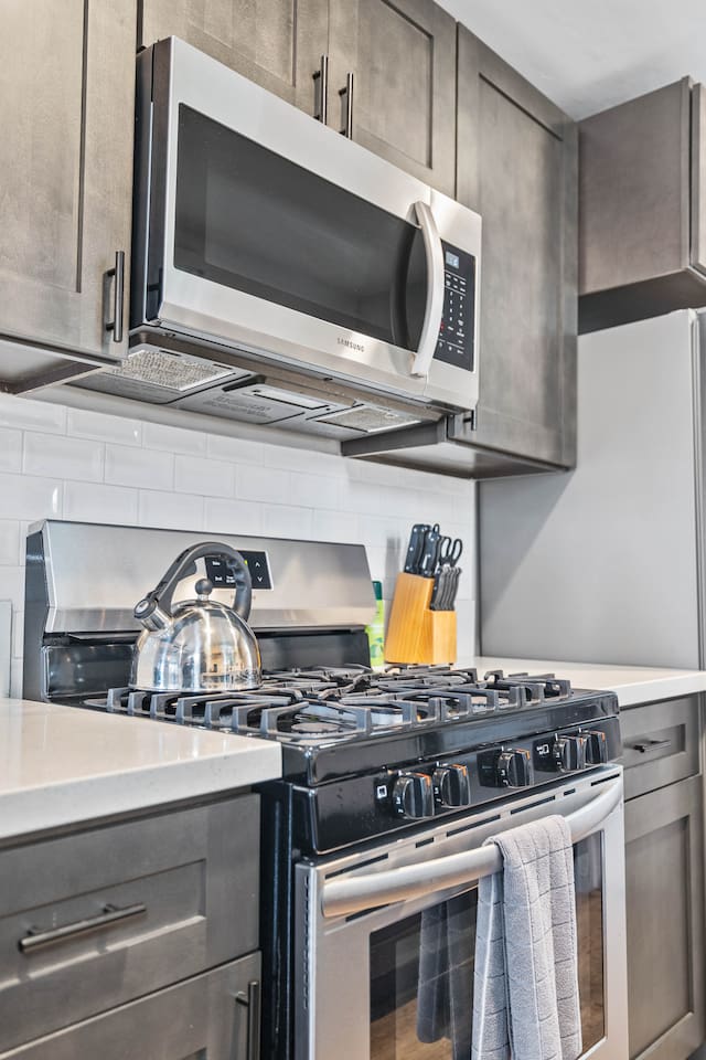 Cook and connect in our spacious kitchen, featuring a stylish sink, oven, and coffee maker. The open floor plan offers a delightful view of the cozy dining table and living room, making it an ideal space for family gatherings.
