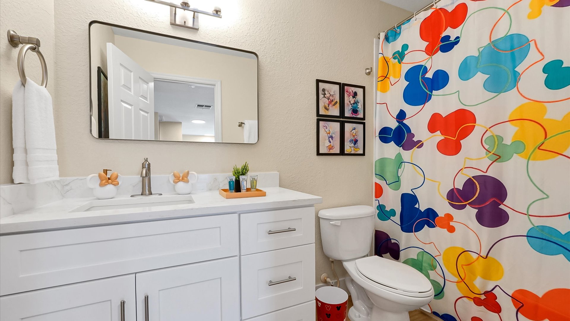 Mickey’s Rainbow Magic Bathroom – Full bathroom with a spacious vanity and shower-and-tub combination