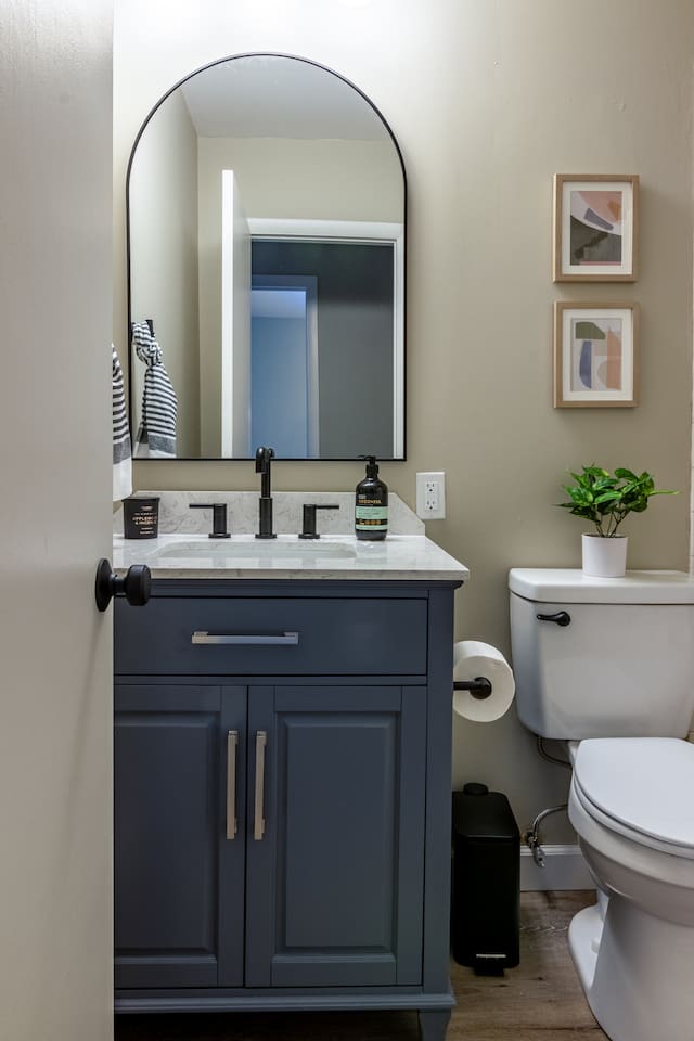A moody navy vanity and matte black fixtures add a touch of understated style to your routine.