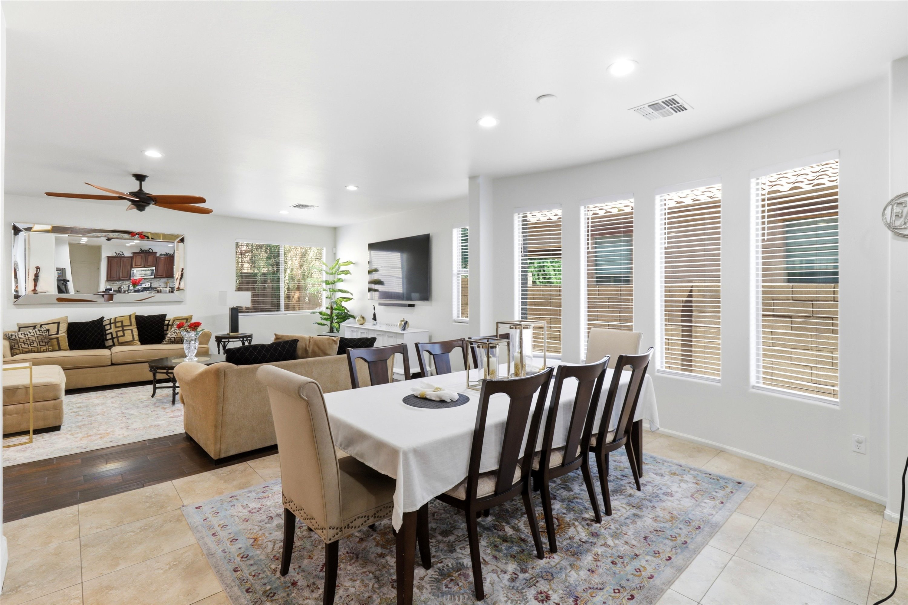 Dining area with a large table, lots of windows, and the living room right nearby.
