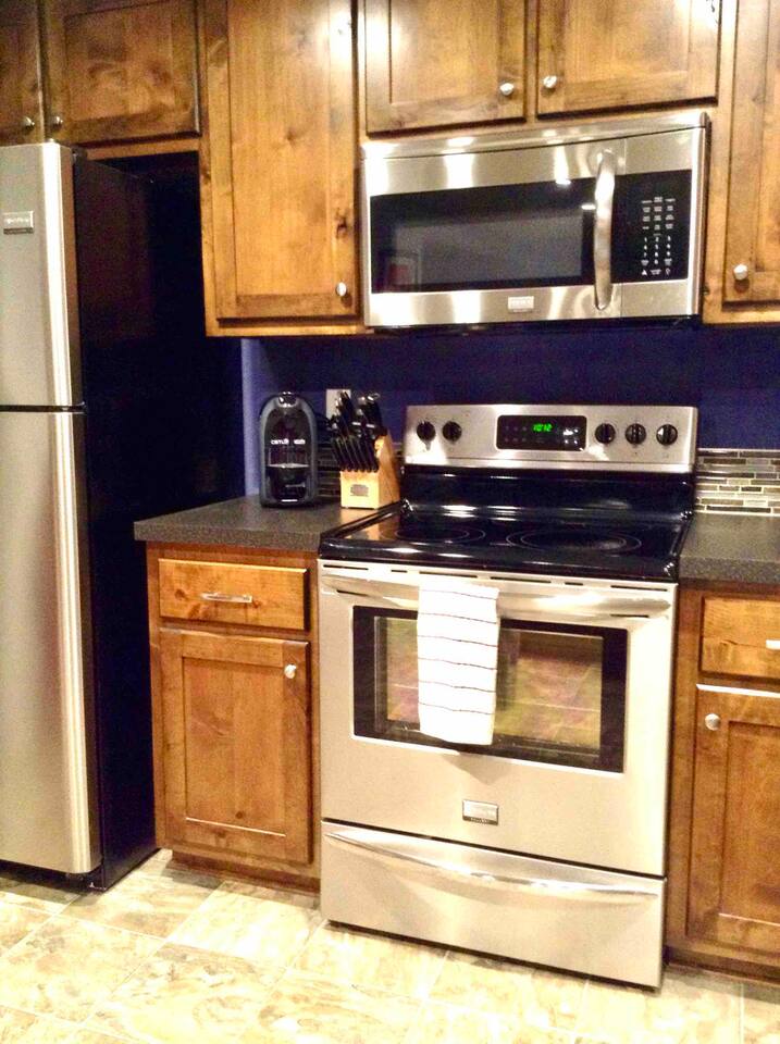 Stainless steel Microwave with range light and vent hood over the Whirlpool Profile series Convection oven. 