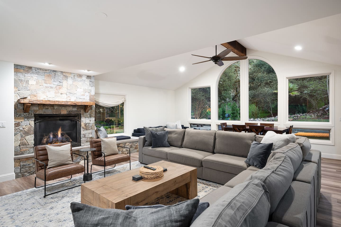Giant sectional and accent chairs open to the gas fireplace and 80" 4K TV. Comfortably seat 12 adults for a movie night!
