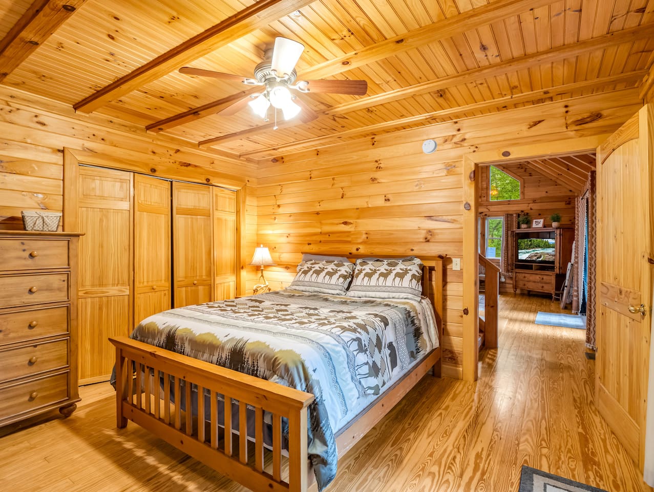 Cozy main-level bedroom with a cozy double bed, rustic wood finishes, and plenty of storage space