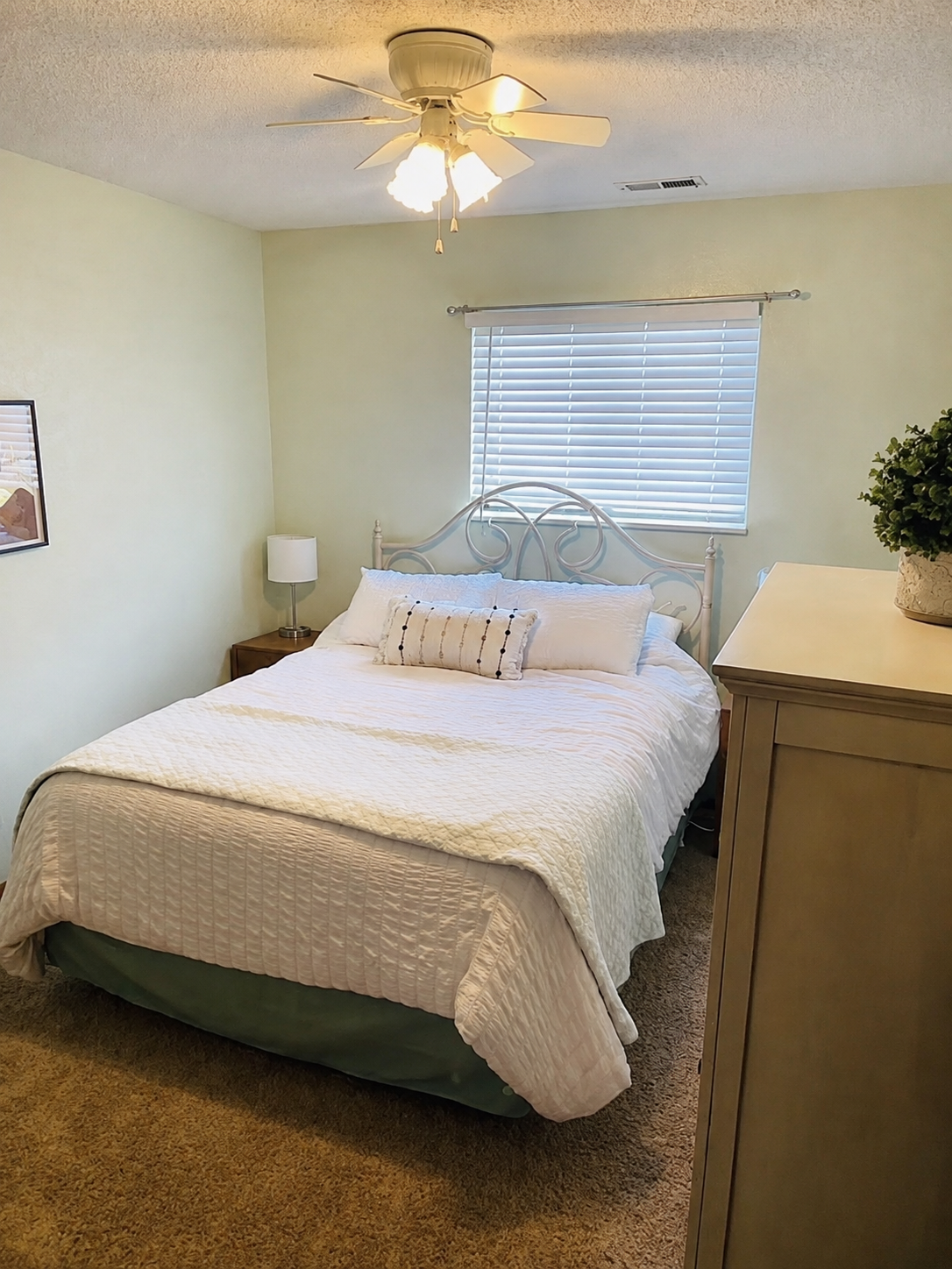 Bedroom with white linens and wooden wardrobe